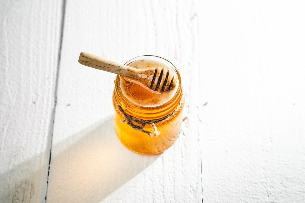 clear glass jar with honey inside it
